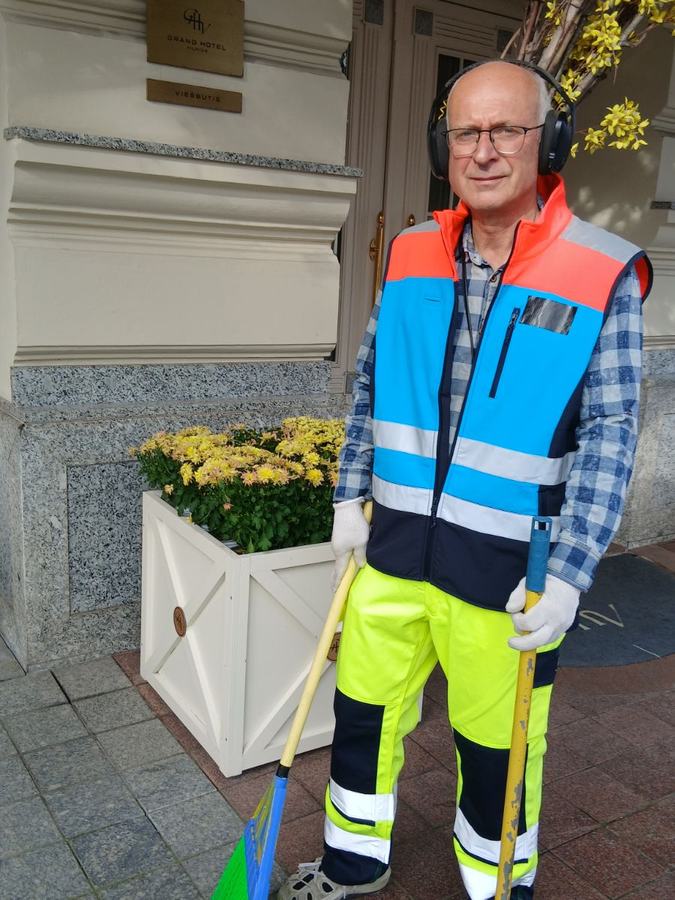 Kiemsargis su šluota prie viešbučio įėjimo