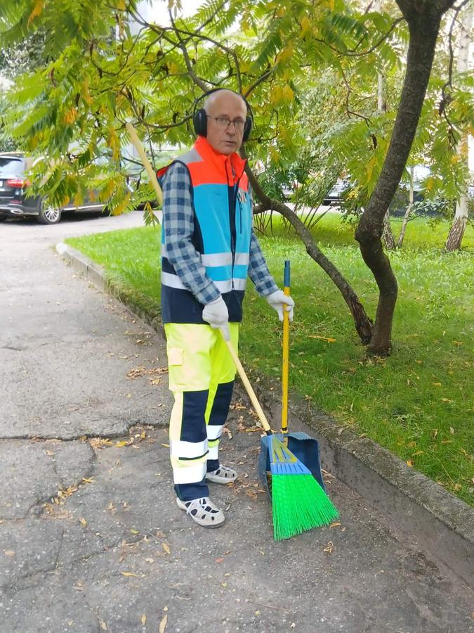 Kiemsargis su šluota ir semtuvėliu ant tako